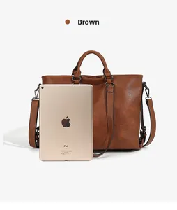 Detailed view of brown leather tote bag showing large capacity fit for an iPad