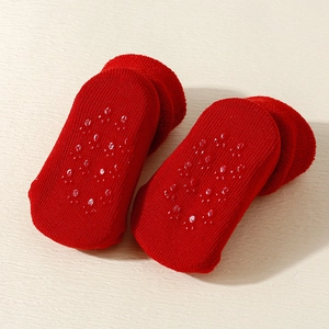 Detail of red baby socks with non-slip silicone grips on bottom for safety