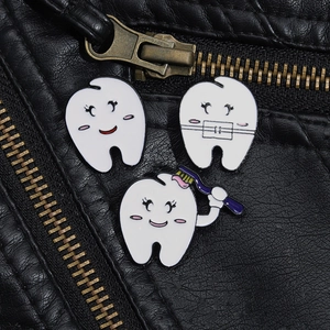 Three-piece dental tooth enamel pin set pinned to a black leather jacket collar