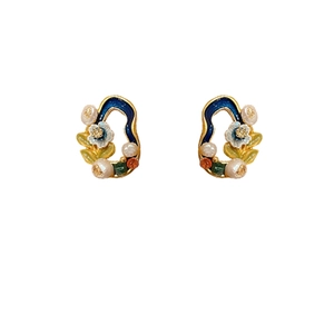 Vintage gold-plated floral earrings with blue enamel and freshwater pearls on white backdrop