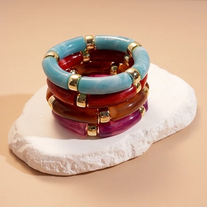 Gros plan détaillé de bracelets en résine acrylique empilés sur une pierre blanche