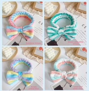 Detail of four colorful striped coral fleece bow headbands for face washing and skincare