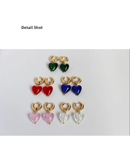 Detail shot of multi-colored heart-shaped glass charms on gold-tone hoop earrings