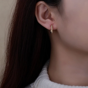 Elegant gold geometric hoop earrings with pavé sparkling zircons on female model