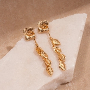Golden flower and leaf tassel earrings with metallic finish on white quartz stone base