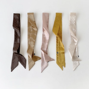 Flache Ansicht von fünf Satin-Schals mit Punkten in Braun, Bronze, Rosa, Gelb und Creme