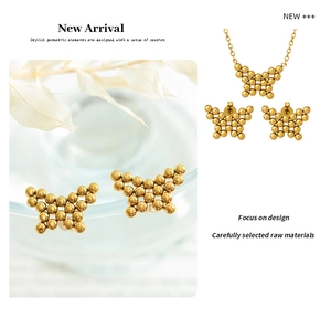 Macro shot of gold butterfly necklace and stud earrings set with spherical beads