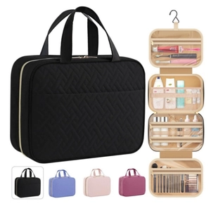 Detail of travel toiletry bag with multiple compartments and hanging hook in black quilted pattern