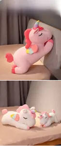 Detail of plush rainbow unicorn pillows with soft filling and cute closed-eye expressions