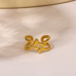 Artistic gold stainless steel open ring with geometric interwoven lines and warm lighting