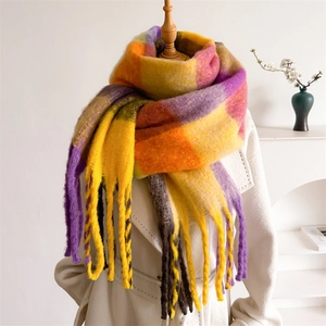 Close-up of fluffy mohair texture and colorful plaid patterns on a thick winter scarf