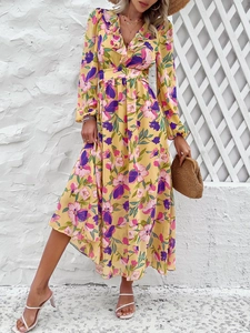 Détail d'une robe jaune à manches longues, col en V, imprimé floral et sac tressé