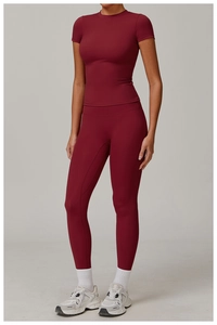 Studio shot of burgundy quick-dry yoga set showing fitted short sleeve top and leggings