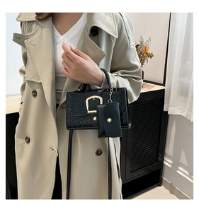 Detail of crocodile pattern crossbody bag with gold buckle and mini pouch accessory