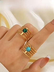Detailed macro view of gold multi-layered rings with green malachite and blue turquoise