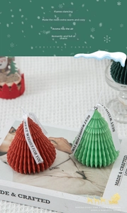 Detail of red and green origami Christmas tree scented candles with elegant white ribbons