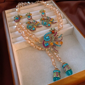 Macro detail of vintage floral jewelry set with colorful rhinestones and beaded tassels