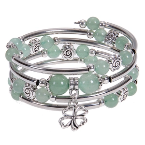 Detail of silver clover pendant and green beads on multilayer wrap bracelet