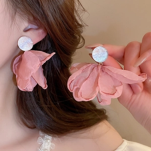 Detail of pink tulle flower earrings with white pearl studs on a model for a beach style