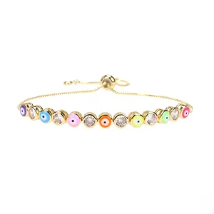 Macro detail of adjustable gold bracelet with colorful enamel evil eyes and zircon stones