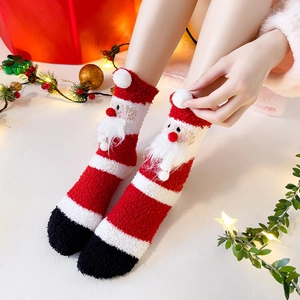 Close-up detail of plush Christmas coral fleece socks, featuring 3D Santa decor for winter.