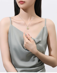 Detailed close-up of a large oval yellow gemstone pendant on a silver necklace chain