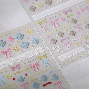 3D embossed nail art stickers with colorful bows, lace patterns, and glitter floral details