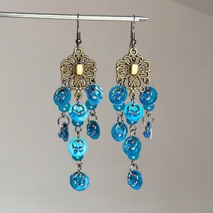 Détail de boucles d'oreilles ethniques rétro avec motifs floraux et sequins bleus