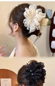 Detail von eleganten Haarspangen mit Chiffonblumen und Strass in Schwarz und Cremeweiß