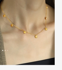 Detail of gold shell pendant necklace on model, showing elegant layered choker style