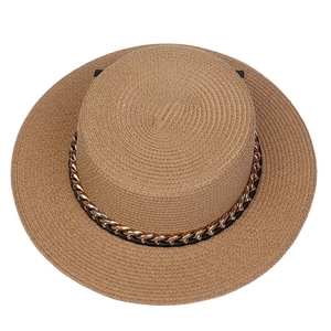 Detail view of khaki straw hat featuring fine weave texture and golden chain link decor