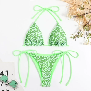 Flat lay of a neon green leopard print bikini with side-tie bottoms and summer accessories