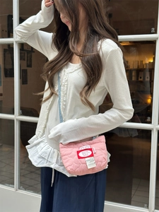 Piccola borsa a tracolla trapuntata rosa con cinturino blu e toppa GOOD TIME su modella