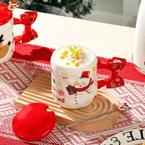 Christmas snowman ceramic mug with red bow handle, lid and spoon in festive setting