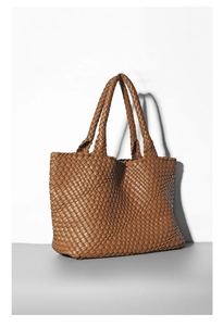 Detailed view of brown woven PU leather tote bag with dual handles on a minimalist surface