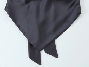 Gros plan sur la texture du tissu en satin gris foncé de cet ensemble deux pièces chic