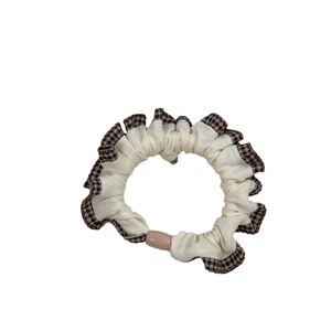 Retro houndstooth plaid scrunchie in cream fabric with a pink bead accent for ponytails