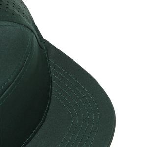 Detalle de costuras en la visera y agujeros de ventilación láser en gorra verde