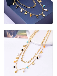 Detail of layered gold titanium necklace featuring star charms and colorful beads