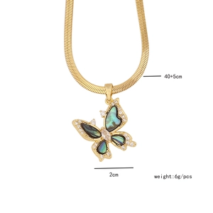 Detail shot of golden butterfly necklace with green abalone shell and product dimensions