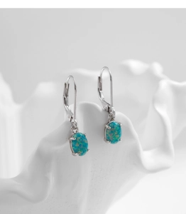 Macro detail of silver lever-back earring featuring a four-prong oval blue opal stone