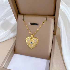 Luxurious gold heart pendant necklace with clear and blue crystals in a jewelry box