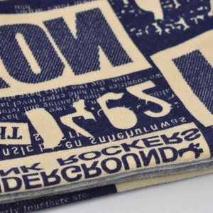 Macro shot of knitted fabric showing vintage underground typography and soft texture