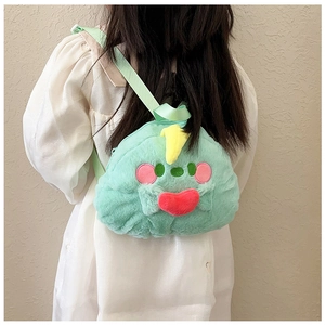 Detail of light green plush monster backpack with red heart on child's back