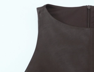 Detail eines dunkelbraunen Lederkleids mit Naht am Ausschnitt und Rückenreißverschluss