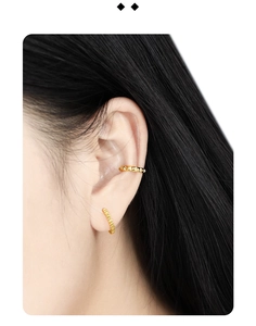 Detailed view of S925 sterling silver ear clips in gold gear design on a model
