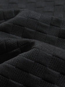 Close-up detail of black men shirt with 3D checkerboard knitted texture and premium fabric