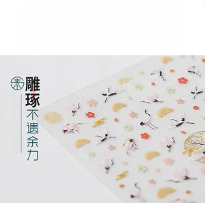 Macro shot of 5D embossed nail stickers featuring cranes, plum blossoms, and golden clouds