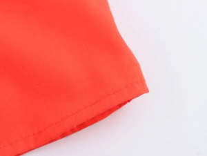 Close-up of red vacation dress showing high-quality stitching and textured fabric details