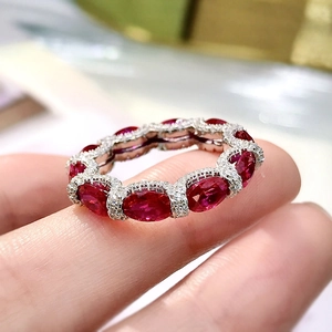 925 silver eternity ring with red oval rubies and diamond accents on a model's hand